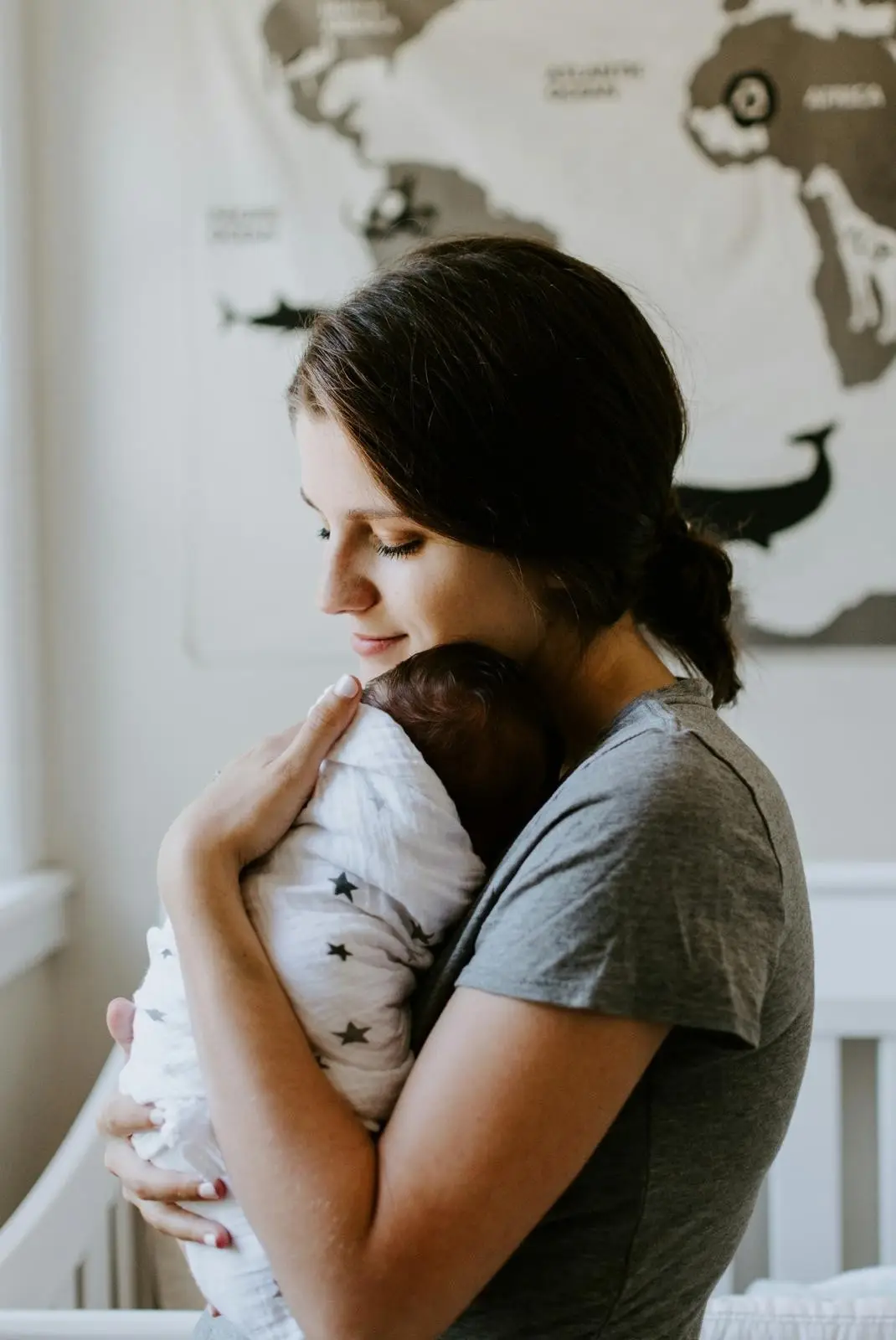 Woman holding baby, pre and postnatal physio check